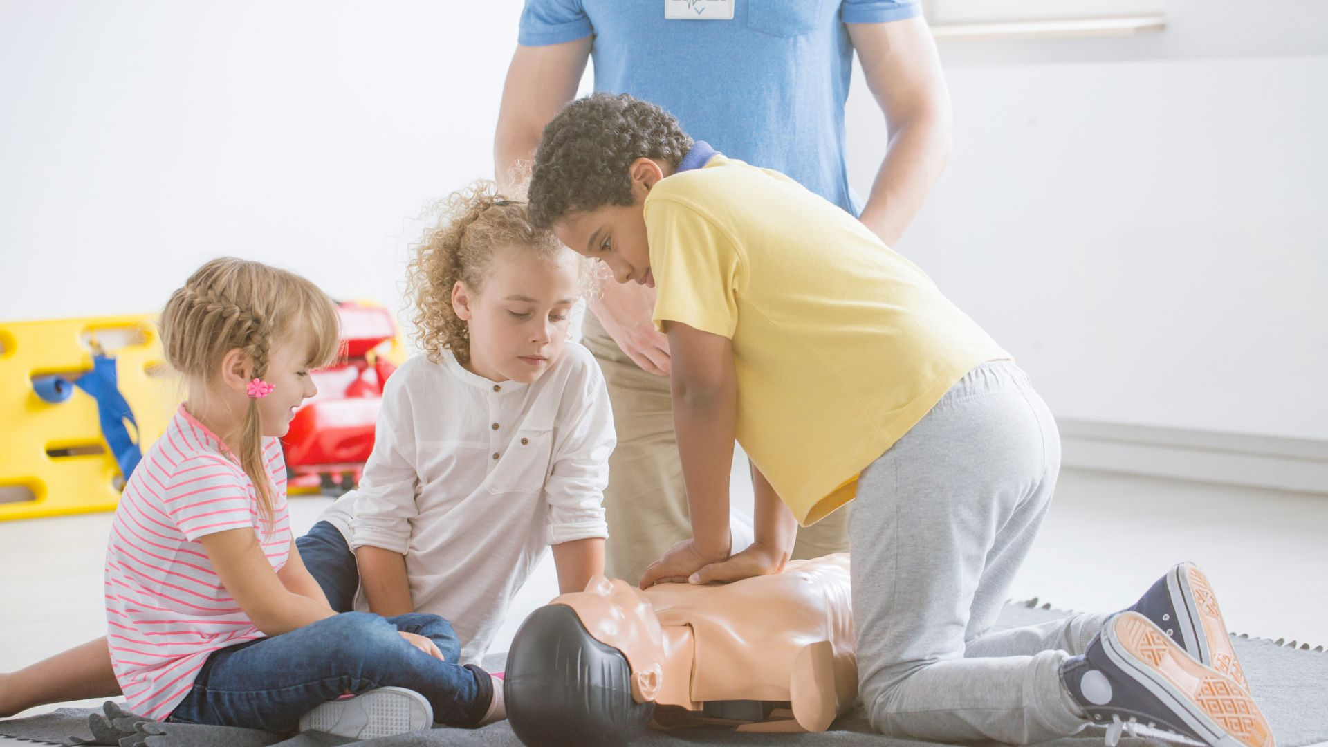Young people practicing CPR on a training mannequin